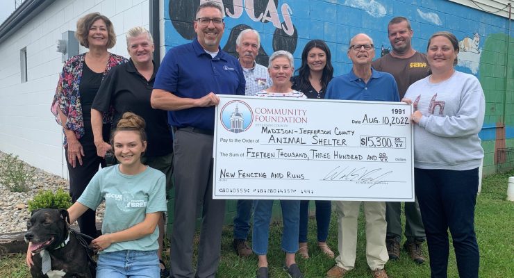 The Community Foundation of Madison & Jefferson County (CFMJC) presented a $15,300 grant to the Madison-Jefferson County Animal Shelter (MJCAS) on August 10, 2022.  On hand for the presentation were: Front Row: (from left) Albert the dog (available for adoption); Jessica Sherman, MJCAS employee; Bill Barnes, CFMJC President & CEO; and Lindsay Stultz, MJCAS Executive Director. Middle Row: (from left) Janet Daugherty, City Animal Control Officer; and Alice Carlson-Jackson & Jim Jackson, Spirit’s Fund Founders. Back Row: (from left) Stephanie Withered, CFMJC Board Chair; Robert Little, Jefferson County Commissioner; Hannah Fagen, MJCAS Advisory Board Secretary; and Paul Geyman, County Animal Control Officer. (Photo Courtesy of CFMJC)
